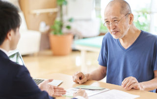 older man discusses paperwork with man in suit