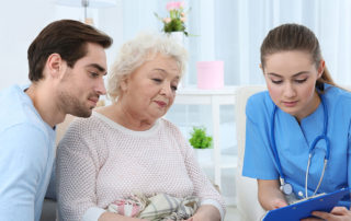 Nurse talking with grandmother and her grandson indoors