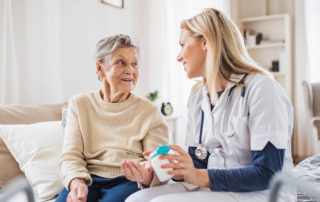 A young health providerexplaining a senior woman how to take medicine and pills.