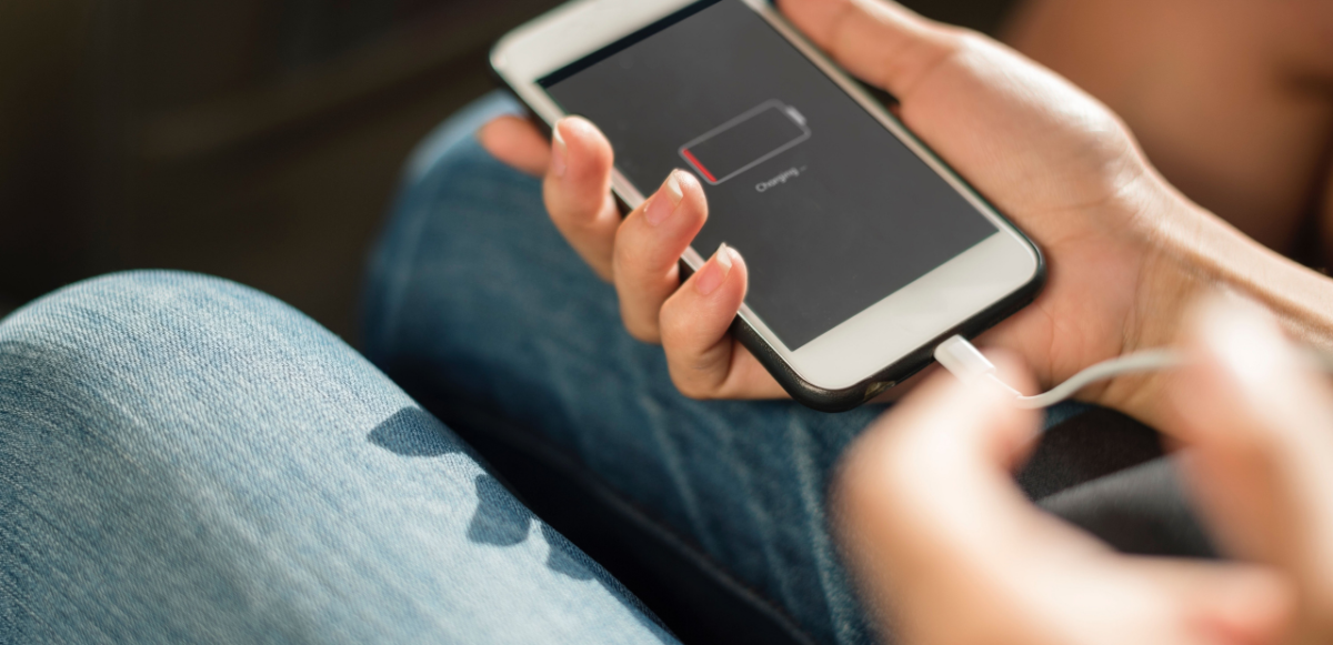 Person charging a cell phone with dead battery