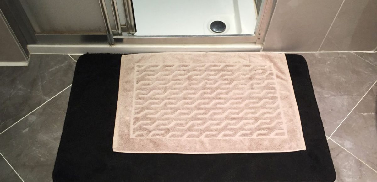 A bathroom mat on top of a non-slick mat.